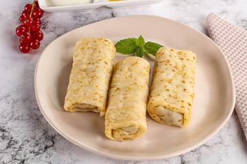 Homemade stuffed pancakes with honey and cream sour