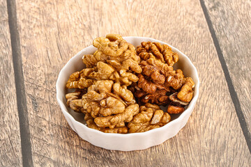 Cracked unshelled walnut in the bowl