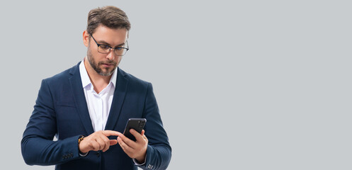 Man in suit using smart phone. Portrait attractive cheerful guy using phone, calling on mobile phone. Handsome man with smart phoneon studio isolated background. Banner, copy space. - Powered by Adobe