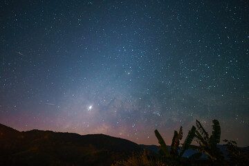 The Milky Way in the clear sky over the silhouette mountains with the Zodiacal light and Venus at...