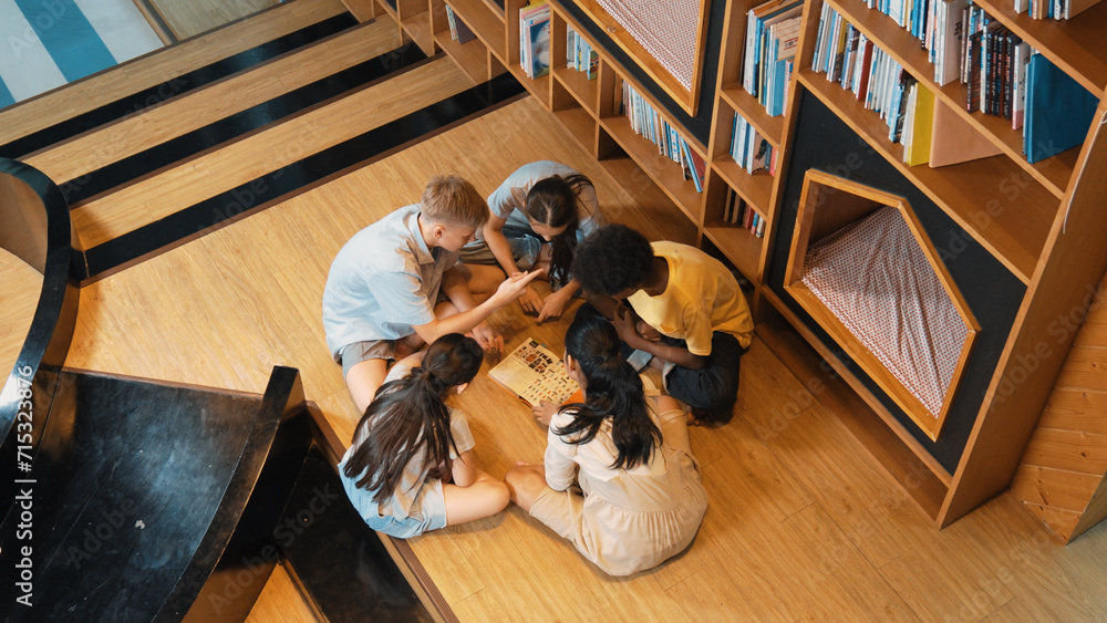 Poster top view of diverse children sitting in circle while looking at camera and waving hands at library s
