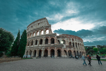 Early evening view of the colosseum in Rome, blue skies with dramatic clouds above the great famous...