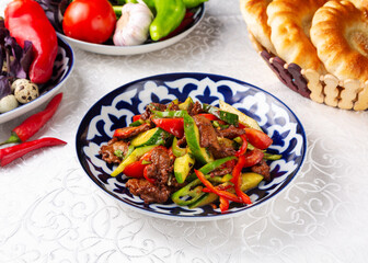 Fried beef with cucumbers, tomato and pepper. Eastern cuisine. Uzbek cuisine.