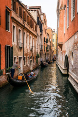 People enjoying gondola ride in a canal in venice - obrazy, fototapety, plakaty