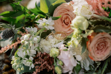 Bride and groom golden rings nestled in bridal bouquet of flowers
