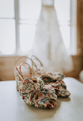 close up of wedding shoes with wedding dress in background.