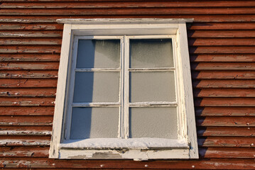 Old wooden building window with frozen glass