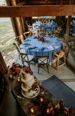 View of interior of barn set up for wedding reception dinner