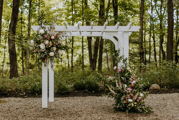 wedding arbor decorated with bridal flowers at wedding ceremony.