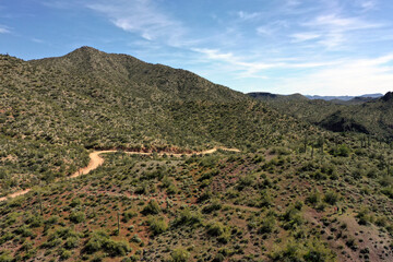 A dirt road winds through mountainous terrain
