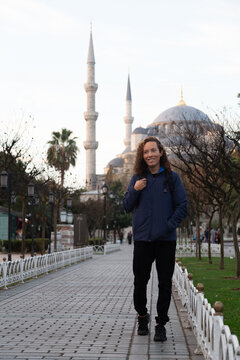 Male tourist with black backpack walking in front of the Blue Mosque