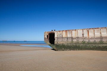 Fototapeta na wymiar Arromanches beach with rusting floating pontoons, Normandy