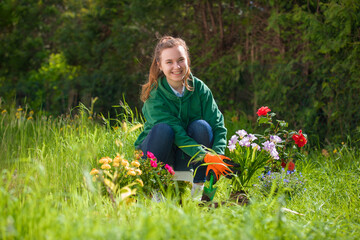 pretty, young woman planting flowers in the soil.