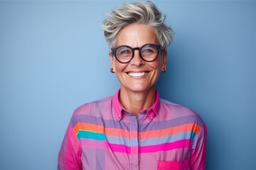 Portrait of a happy senior woman wearing eyeglasses against blue background