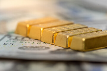group of gold bar lie on 100 US dollar bills background