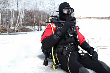 Diver at the edge of an ice hole, ready to immerse