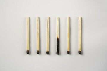 Whole and burnt matches lined up in a row on a white background. The concept of emotional burnout...