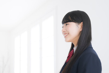 使いやすい白背景で横顔で笑顔の女子高生...