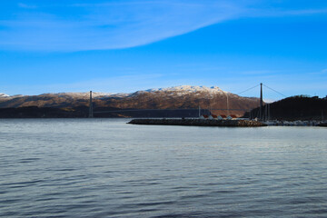 landscape with a big cable stayed bridge and mountains in the background