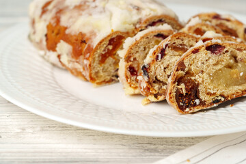 Christmas stollen on plate on white wooden table