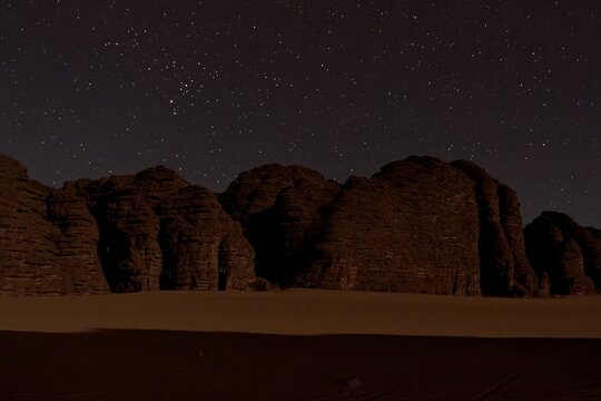 The night sky and the Tikoubaouine rock formations in the tourist area of Immourouden, near the town of Djanet. Tassili n Ajjer National Park. Sahara desert. Algeria. Africa.