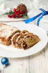 Christmas stollen on plate on white wooden table