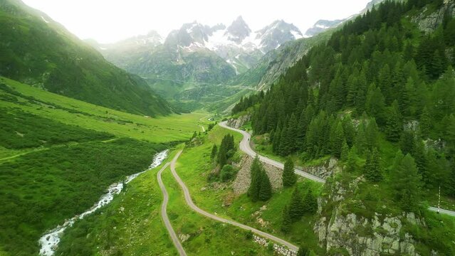 Aerial drone view of scenic Oberalp pass drive in Swiss alps. Switzerland summer tourism destination. Alpine road trip road.