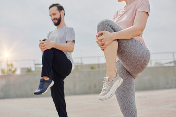 Man and woman warming up, stretching outdoors