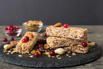 Various granola bars on table background. Cereal granola bars. Superfood breakfast bars with oats, nuts and berries, close up. Superfood concept