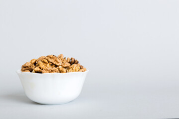 Fresh healthy walnuts in bowl on colored table background. Top view Healthy eating bertholletia concept. Super foods