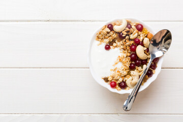 Healthy breakfast food with granola, yogurt, fruits and nuts. Dessert parfait with dried fruits for breakfast