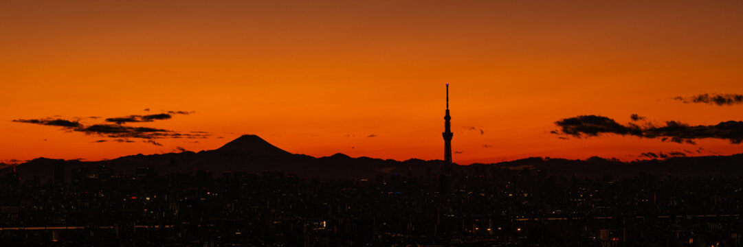 Wide panoramic image of silhouette of Tokyo central area with Mount Fuji and Tokyo skytree at sunset.