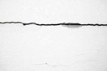 The cement wall has horizontal cracks.