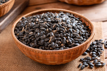 Dried and peeled sunflower seeds in a wooden plate on a table.