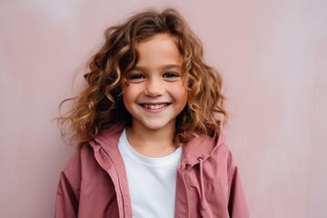 Portrait of a cute little girl with curly hair in a pink jacket