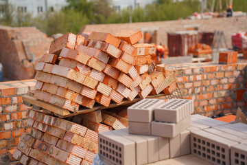 Pallets with red bricks at construction site