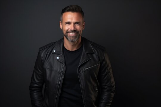 Portrait of a handsome mature man in leather jacket on dark background