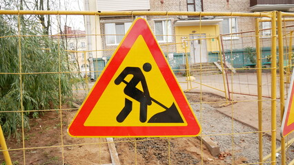 Road works signs on a fence, construction and building industry.