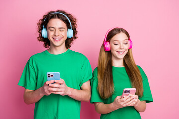 Photo of two best friends test their new earphones blue and purple colors devices with bluetooth...