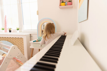 Little girl playing a piano