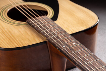 Obraz premium Classical guitar close up. Acoustic guitar on wood background.Music instrument concept