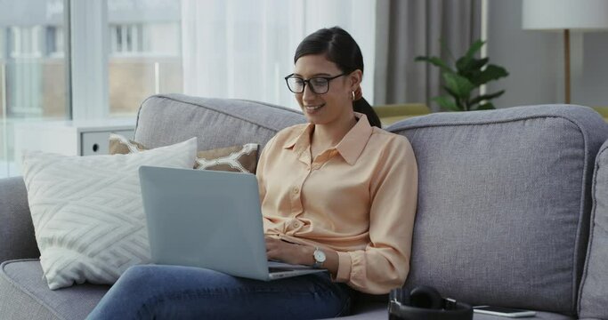 Businesswoman, happy and laptop for email on sofa, relax and freelancer for online project in home. Young person, remote work or positive for internet research or connected in living room by computer