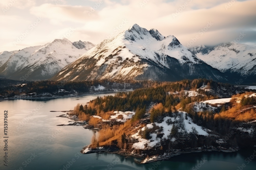 Poster an aerial view of a mountain range with a lake in the foreground and snow covered mountains in the b