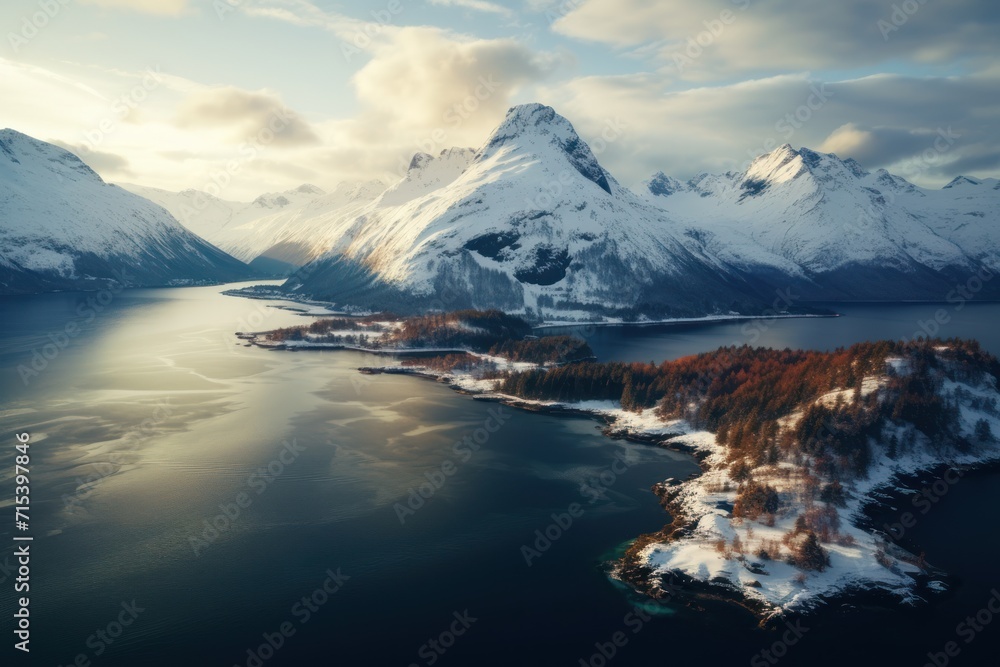 Poster an aerial view of a mountain range with a lake in the foreground and snow covered mountains in the b