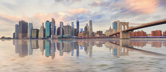 Panorama view of New York city and Brooklyn bridge at sunset.