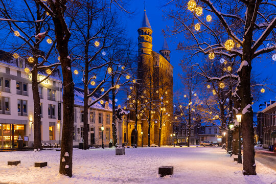 Maastricht, Netherlands 01-19-2024 Basilica of Our Lady and the square during twilight, covered with fresh snow during winter time and illuminated with Christmas decoration, creating a magical scene 