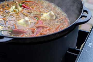 Real Uzbek pilaf in a huge cauldron. Cooking national dishes in Uzbekistan. Rice with meat in a cauldron. Traditional pilaf cooking