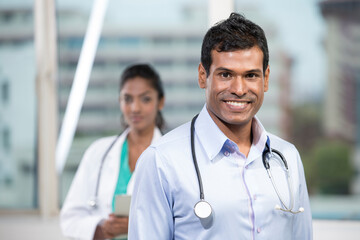 Male Indian doctor standing with his colleague
