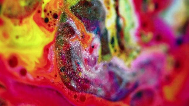 Glitter fluid flow. Paint mix water. Defocused vibrant red pink yellow color shimmering marble texture oil bubble ink wave abstract art background.