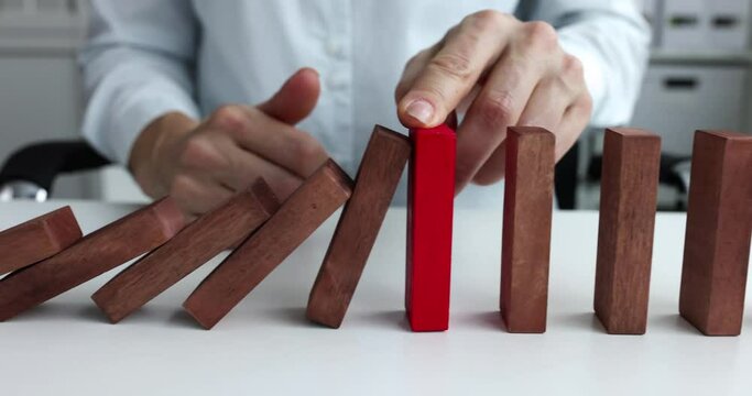 Woman stoping falling wooden blocks with hand 4k movie slow motion. New strategies in business concept